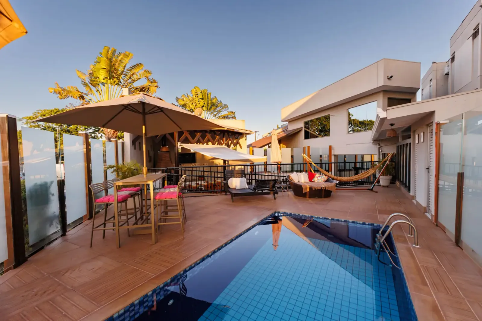 Área da piscina do Tonello Business Hotel ao entardecer